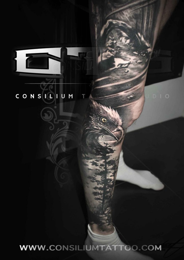 pierna tatuada con la temática naturalista con un águila y un fondo de bosque